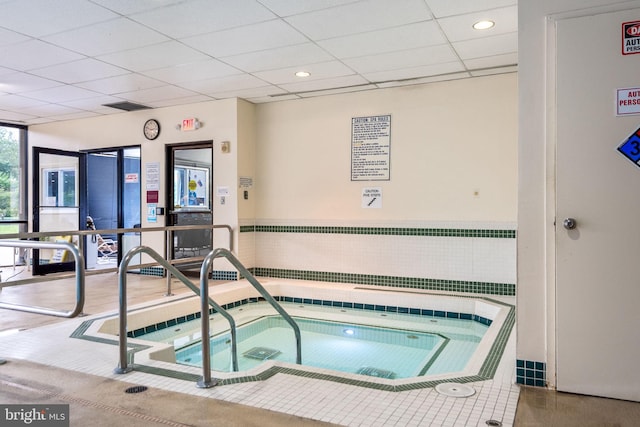 view of swimming pool with an indoor hot tub