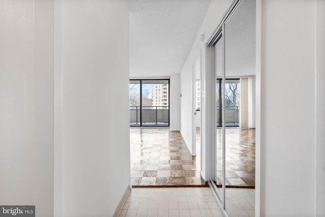 hall featuring expansive windows and a textured ceiling