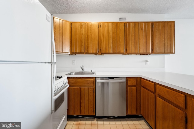 kitchen featuring sink, white appliances, and a textured ceiling