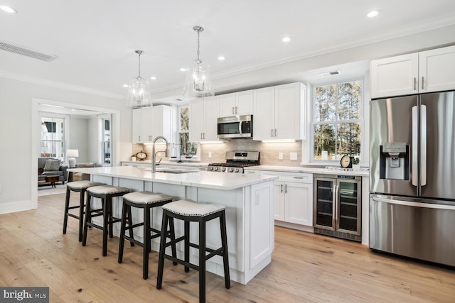 kitchen with stainless steel appliances, beverage cooler, a center island, and white cabinets