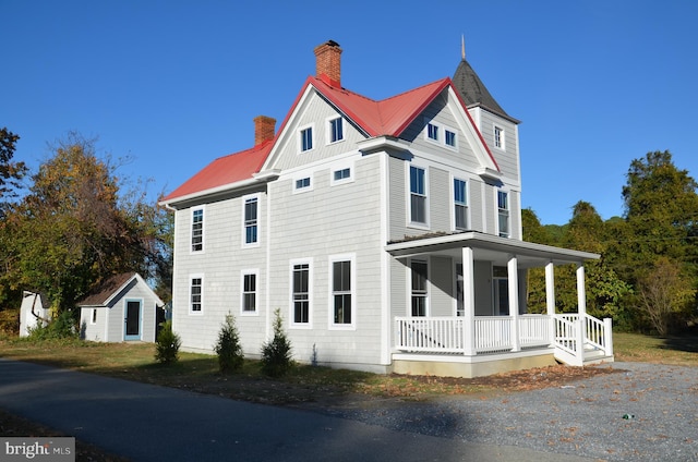 view of side of property with an outbuilding and a porch