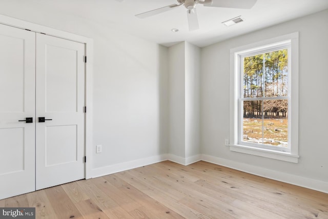 unfurnished bedroom featuring ceiling fan, light hardwood / wood-style floors, and a closet