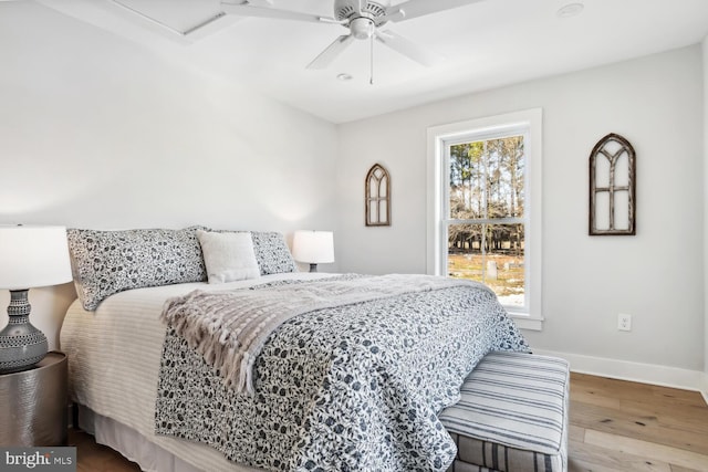 bedroom with ceiling fan, hardwood / wood-style floors, and multiple windows