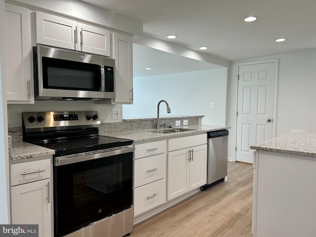 kitchen featuring sink, white cabinetry, light stone countertops, and appliances with stainless steel finishes