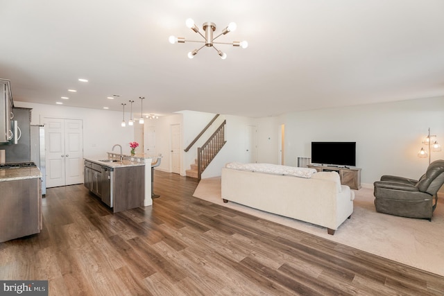 living room with an inviting chandelier, dark hardwood / wood-style floors, and sink