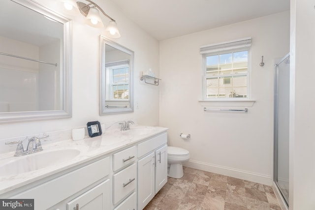 bathroom with vanity, a shower with door, and a healthy amount of sunlight