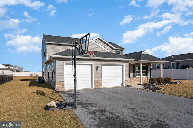 exterior space with a yard, a garage, central air condition unit, and covered porch