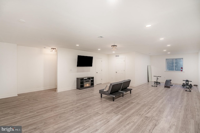 exercise room with light wood-type flooring