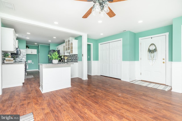 kitchen featuring white cabinetry, tasteful backsplash, dark hardwood / wood-style flooring, and light stone counters