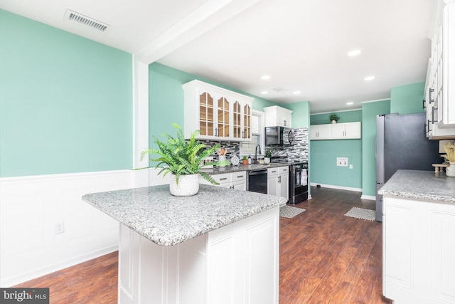 kitchen featuring light stone counters, stainless steel range, dishwasher, and white cabinets