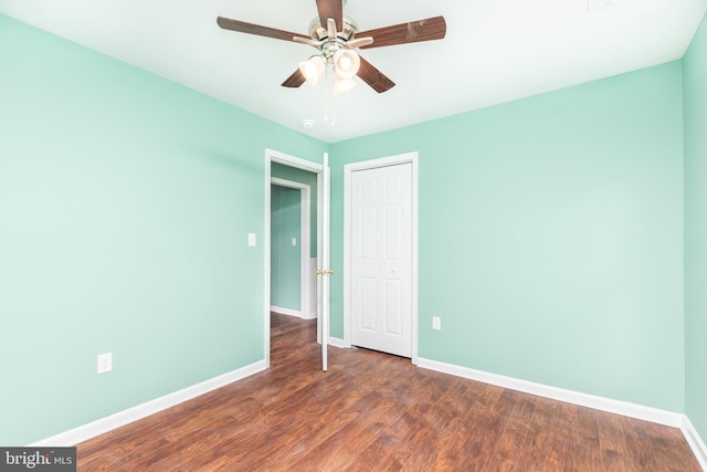 unfurnished room featuring dark wood-type flooring and ceiling fan