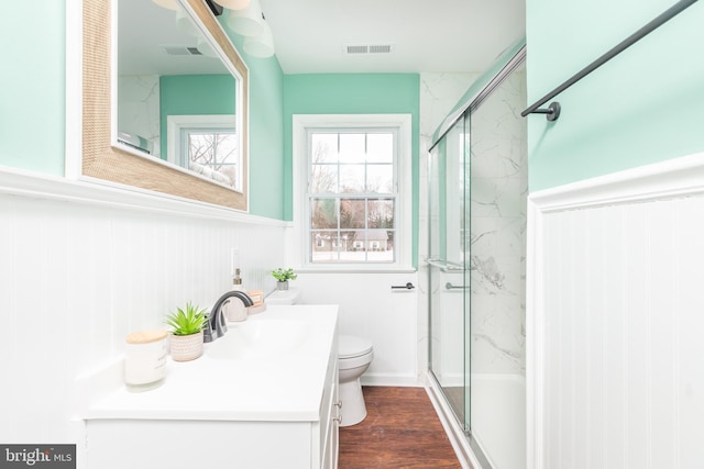 bathroom featuring vanity, an enclosed shower, hardwood / wood-style floors, and toilet