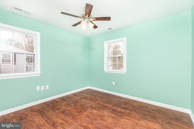 empty room with dark wood-type flooring and ceiling fan