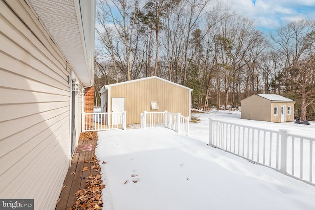 snowy yard featuring an outdoor structure