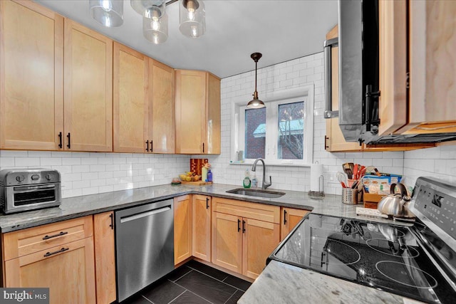 kitchen featuring hanging light fixtures, sink, dark stone countertops, stainless steel appliances, and light brown cabinets