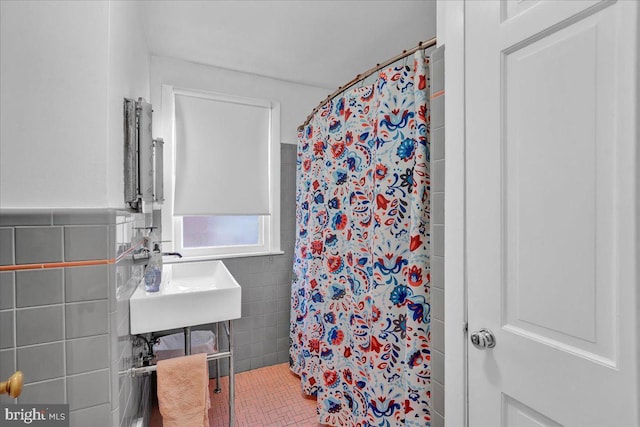 bathroom featuring a shower with curtain, sink, tile patterned flooring, and tile walls