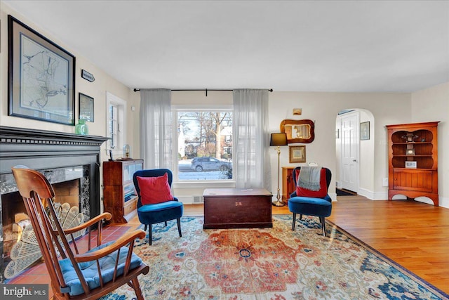 sitting room with a premium fireplace and wood-type flooring