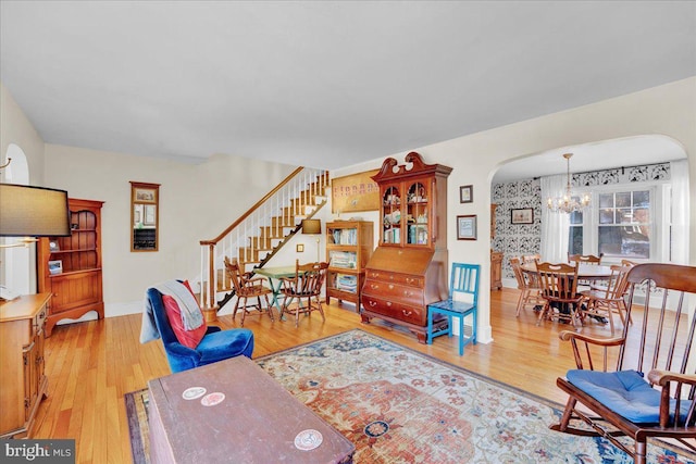 living room featuring light wood-type flooring and a notable chandelier