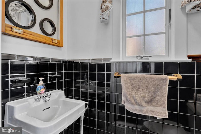 bathroom featuring sink and tile walls