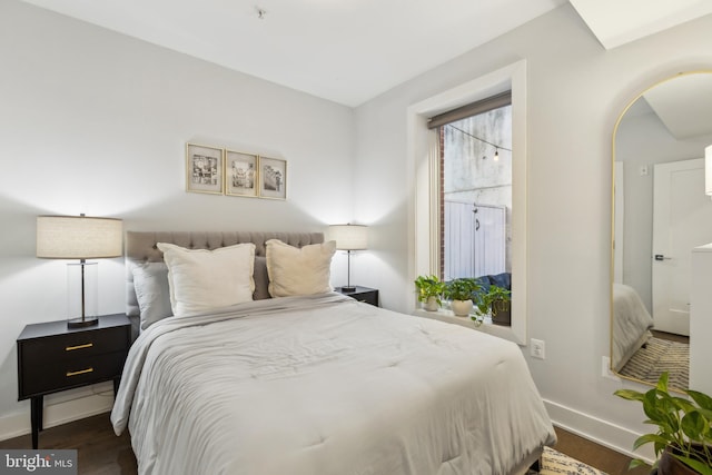 bedroom with dark hardwood / wood-style floors