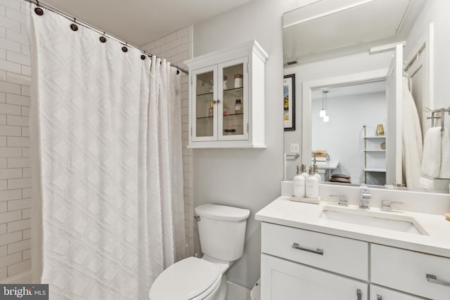 bathroom with vanity, toilet, and curtained shower