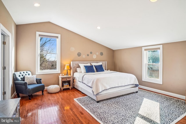 bedroom with lofted ceiling, hardwood / wood-style floors, and multiple windows