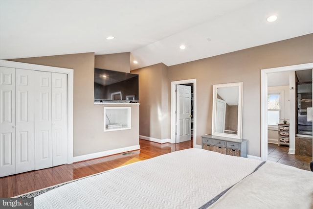 bedroom with dark wood-type flooring, connected bathroom, and vaulted ceiling