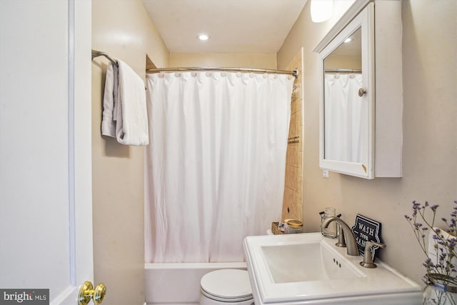 full bathroom featuring shower / bath combination with curtain, toilet, and sink