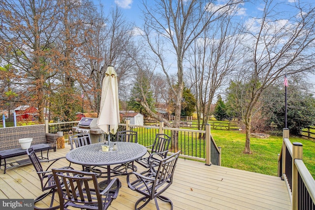 wooden terrace featuring a grill and a lawn