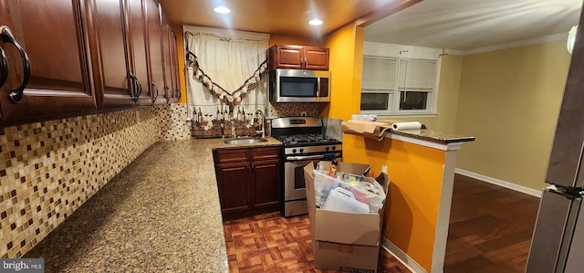 kitchen featuring sink, ornamental molding, appliances with stainless steel finishes, light stone countertops, and backsplash