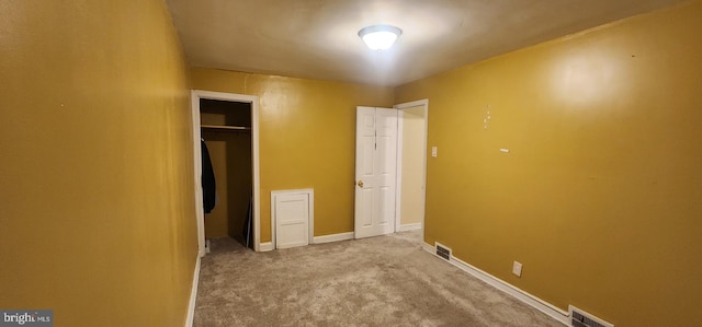 unfurnished bedroom featuring light colored carpet and a closet