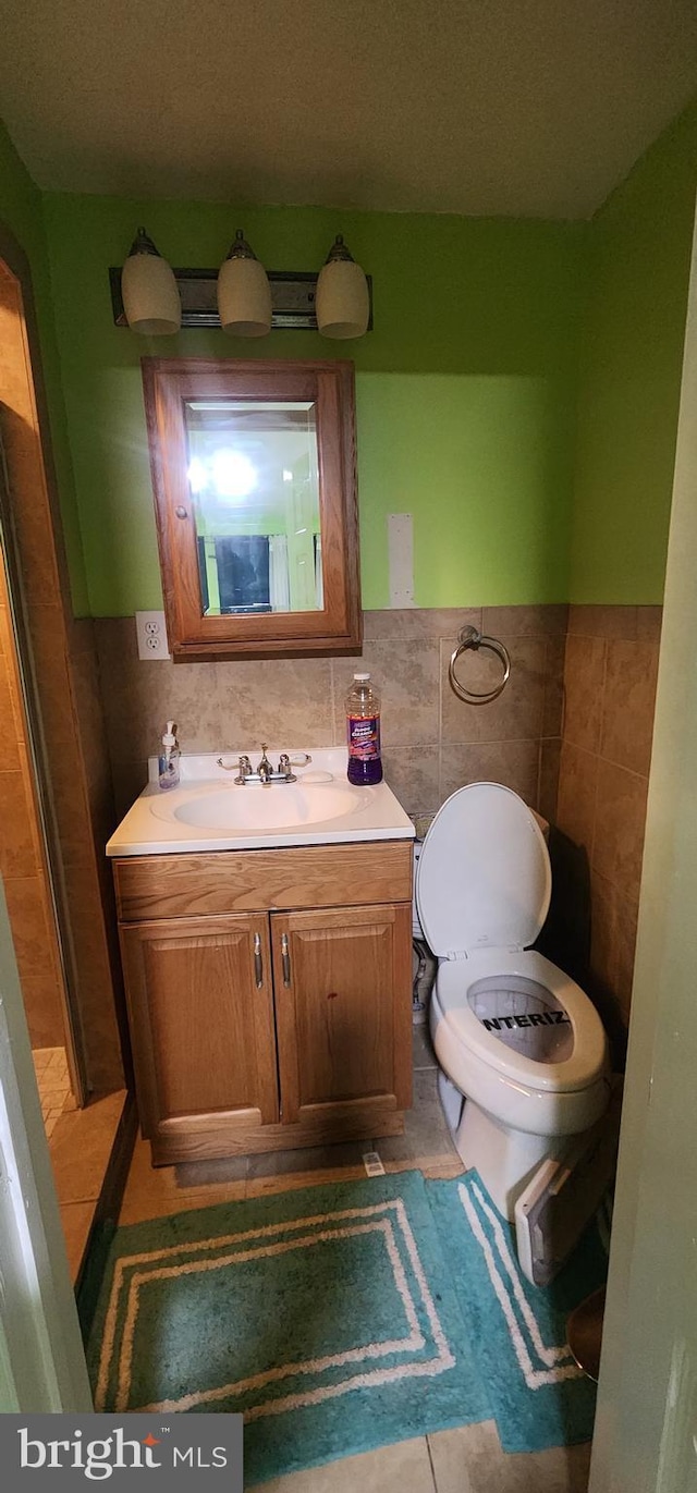 bathroom with vanity, tile patterned flooring, and tile walls