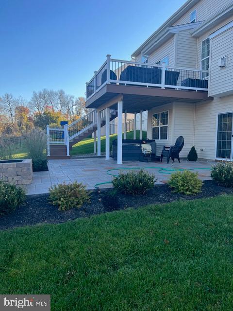 rear view of house featuring a patio area, a yard, and a deck