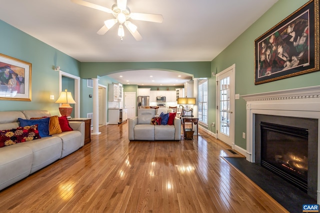 living room with light hardwood / wood-style flooring and ceiling fan