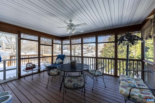 unfurnished sunroom with ceiling fan