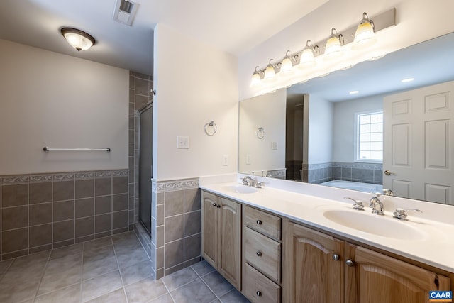 bathroom featuring tile patterned flooring, vanity, tile walls, and separate shower and tub