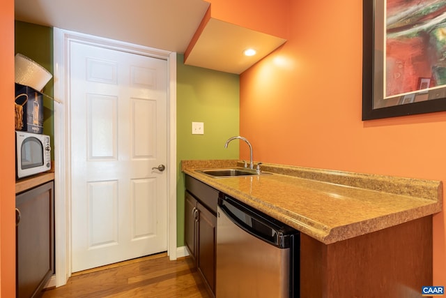 bar featuring sink, hardwood / wood-style flooring, and stainless steel dishwasher