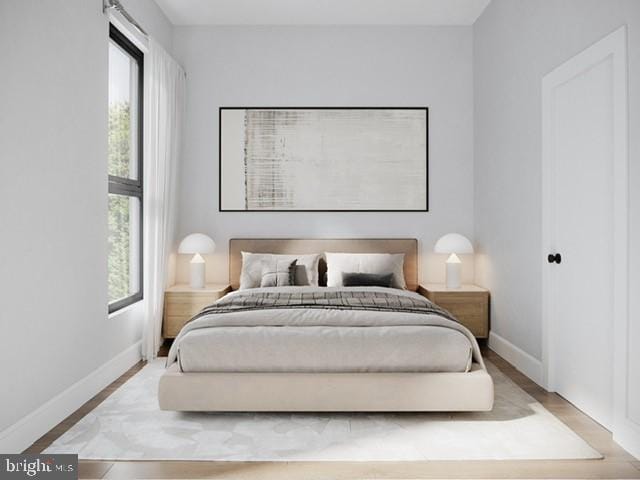 bedroom with multiple windows and light hardwood / wood-style floors