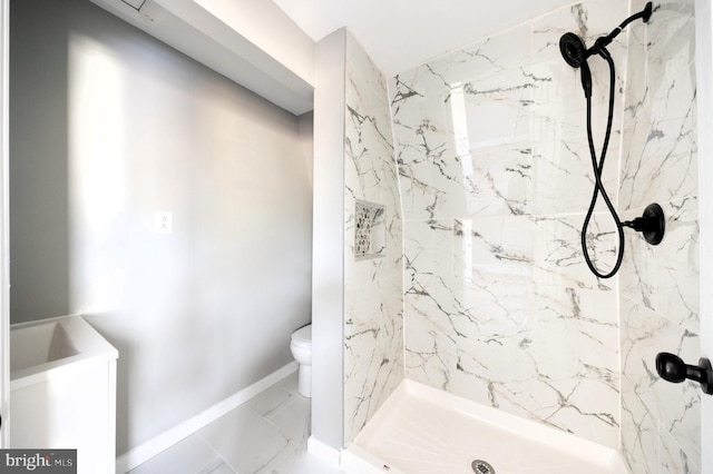 bathroom featuring a tile shower and toilet