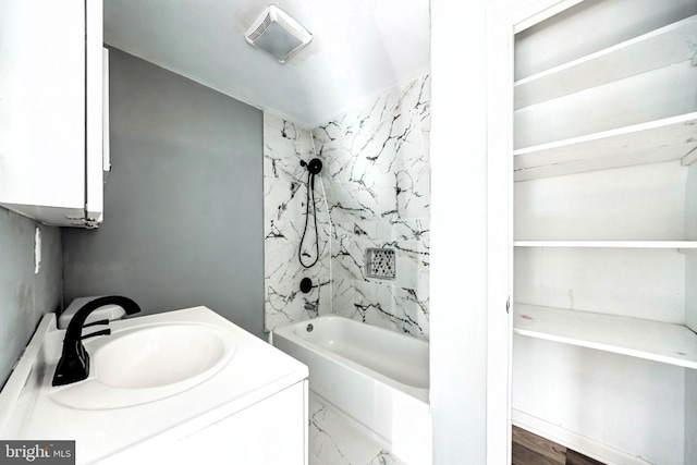 bathroom with tiled shower / bath combo and vanity