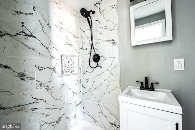 bathroom with vanity and a tile shower