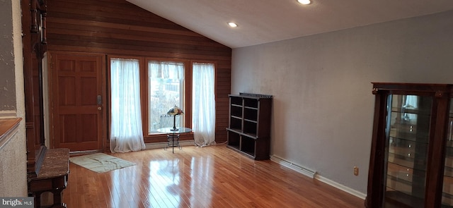 interior space with light wood-type flooring and vaulted ceiling