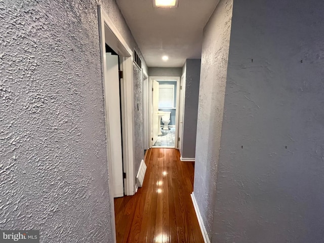 hallway with dark hardwood / wood-style flooring