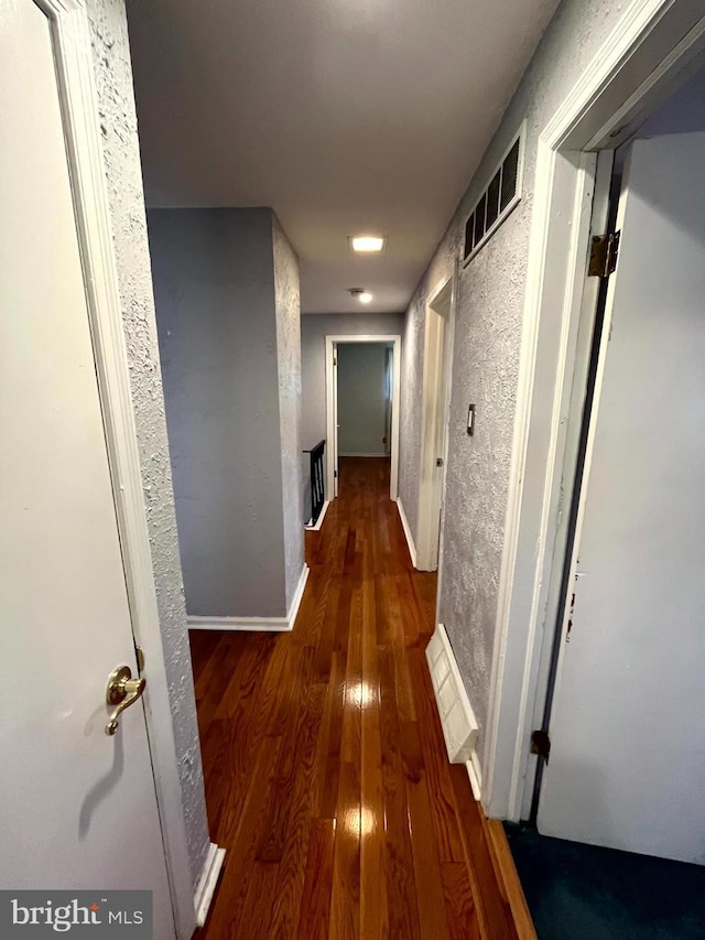 hallway with dark hardwood / wood-style flooring