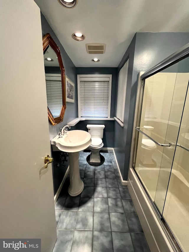 bathroom with toilet and enclosed tub / shower combo