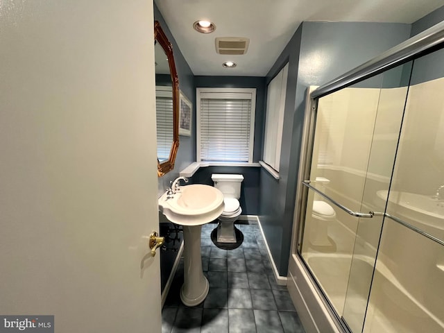 bathroom featuring toilet, tile patterned flooring, and enclosed tub / shower combo