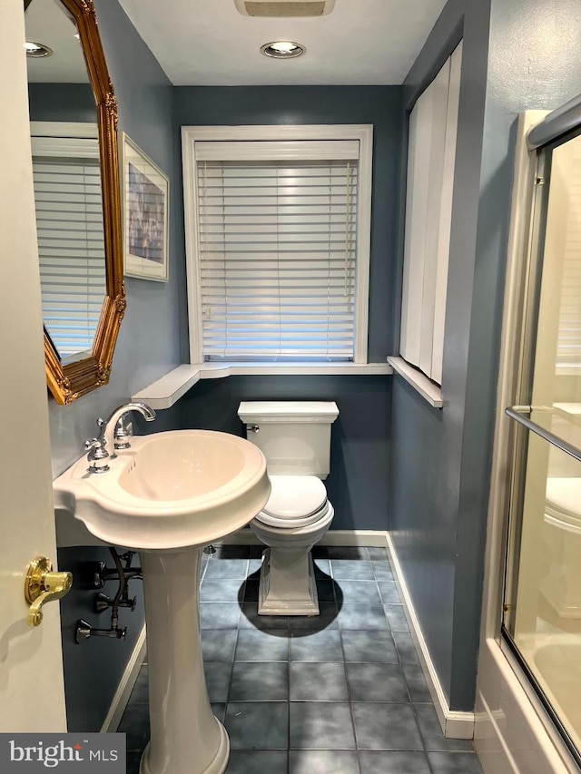 bathroom featuring bath / shower combo with glass door and toilet