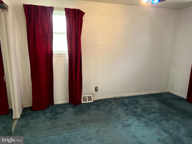 spare room with dark carpet