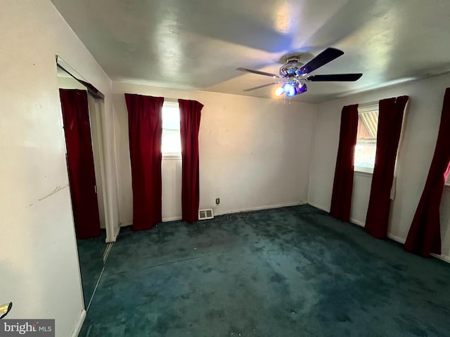 carpeted spare room with ceiling fan