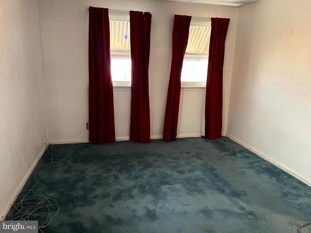 unfurnished room with dark colored carpet